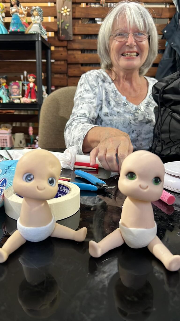 Dos muñecos bebé de porcelana fría sobre la mesa de trabajo